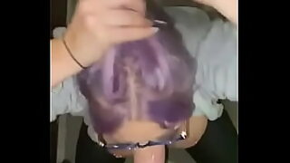 a girl with a purple hair suck pencil